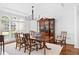 Formal dining room with a large wooden table, china cabinet, and window offering bright, natural light at 9115 Nesbit Lakes Dr, Alpharetta, GA 30022