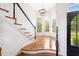 Grand entryway featuring hardwood floors, staircase, and natural light from large windows at 9115 Nesbit Lakes Dr, Alpharetta, GA 30022