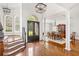 Grand foyer featuring hardwood floors, a staircase, and an elegant dining area filled with natural light at 9115 Nesbit Lakes Dr, Alpharetta, GA 30022