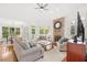 Bright and airy living room featuring a stone fireplace, hardwood floors, and large windows with views of the surrounding landscape at 9115 Nesbit Lakes Dr, Alpharetta, GA 30022