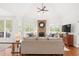 Bright living room with a stone fireplace, seating area, and hardwood floors, creating a warm and inviting atmosphere at 9115 Nesbit Lakes Dr, Alpharetta, GA 30022