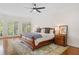 Bright and airy main bedroom featuring hardwood floors, a large bed, and plenty of natural light at 9115 Nesbit Lakes Dr, Alpharetta, GA 30022