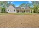 The back exterior of the house features a covered porch with white columns and large backyard surrounded by mature trees at 12 Cedar Gate Ln, Kingston, GA 30145