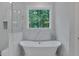 Luxurious bathroom with a free-standing soaking tub beneath a window, providing a serene view at 12 Cedar Gate Ln, Kingston, GA 30145
