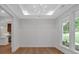 Elegant dining room featuring wainscoting, tray ceiling, modern chandelier, and hardwood floors at 12 Cedar Gate Ln, Kingston, GA 30145
