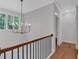 Hallway with hardwood floors, black metal railing, and a modern chandelier at 12 Cedar Gate Ln, Kingston, GA 30145