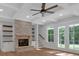 Cozy living room featuring a stone fireplace, built-in shelves, and French doors leading to the patio at 12 Cedar Gate Ln, Kingston, GA 30145