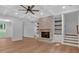 Bright living room with a stone fireplace, built-in shelving, and a staircase leading to the upper level at 12 Cedar Gate Ln, Kingston, GA 30145