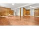 Spacious basement featuring paneled walls, laminate flooring, and access to the upper level at 1355 Tucker Woods Dr, Norcross, GA 30093
