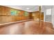 Finished basement with paneled walls, laminate flooring, and a staircase to the upper level at 1355 Tucker Woods Dr, Norcross, GA 30093