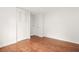 Minimalist bedroom showcasing hardwood floors, closet with paneled doors, and neutral walls at 1355 Tucker Woods Dr, Norcross, GA 30093