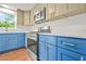 Modern kitchen with blue lower cabinets, tan upper cabinets, stainless steel appliances, and natural light at 1355 Tucker Woods Dr, Norcross, GA 30093