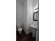 Half bathroom featuring a pedestal sink, toilet, modern mirror, and dark wood-like flooring at 2275 Copper Trail Ln, Buford, GA 30519