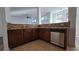 Kitchen featuring dark wood cabinetry, granite countertops, stainless steel appliances, and tile flooring at 2275 Copper Trail Ln, Buford, GA 30519