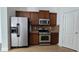 Kitchen with stainless steel appliances, granite countertops, beautiful backsplash, and dark wood cabinets at 2275 Copper Trail Ln, Buford, GA 30519