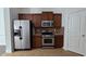 Kitchen with stainless steel appliances, granite countertops, beautiful backsplash, and dark wood cabinets at 2275 Copper Trail Ln, Buford, GA 30519