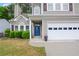 Home with traditional architectural details, a vibrant blue front door, manicured greenery, and convenient two-car garage at 3381 Grovewood Ln, Duluth, GA 30096