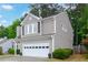 Exterior view of home showing well manicured yard, garage, trees and showing the home's architectural structure at 3381 Grovewood Ln, Duluth, GA 30096