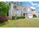 Lovely view of the exterior of the residence, including the manicured lawn, two-car garage, mature trees and inviting landscaping at 3381 Grovewood Ln, Duluth, GA 30096