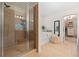 Bright bathroom featuring a glass shower, a soaking tub, and a doorway to a walk-in closet at 4120 Winterberry Rd, Cumming, GA 30040