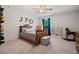 Cozy bedroom featuring a ceiling fan, blue curtains, a bookshelf, and carpet at 4120 Winterberry Rd, Cumming, GA 30040