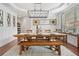 Formal dining room featuring elegant lighting, wainscoting, and a farmhouse-style table set at 4120 Winterberry Rd, Cumming, GA 30040