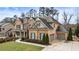 Brick home featuring a well-manicured lawn, a two-car garage, and mature trees at 4120 Winterberry Rd, Cumming, GA 30040
