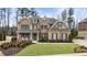 Inviting two-story brick home featuring manicured landscaping, shutters, and a welcoming front porch at 4120 Winterberry Rd, Cumming, GA 30040
