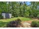 Large backyard with green lawn, storage shed, professional landscaping, and mature trees at 3018 Monterey Dr, Decatur, GA 30032