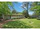 Spacious backyard with a green lawn, trees, and a fire pit at 3018 Monterey Dr, Decatur, GA 30032
