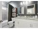 Bathroom features a double sink vanity with granite countertops, sleek fixtures, and a shower-tub combo with gray tile at 3018 Monterey Dr, Decatur, GA 30032
