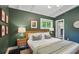 Cozy bedroom with dark green walls, recessed lighting, large windows, hardwood floors, and two end tables with lamps at 3018 Monterey Dr, Decatur, GA 30032