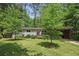 Charming single-story home with mature trees, lush lawn, and a covered parking area at 3018 Monterey Dr, Decatur, GA 30032