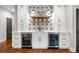 A bar in the basement featuring beverage coolers, and white cabinets at 3642 River Club Dr, Cumming, GA 30041