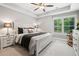 This bedroom offers a neutral color scheme with ceiling fan and natural light streaming through the windows at 3642 River Club Dr, Cumming, GA 30041