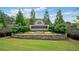 Elegant stone entrance to the Chattahoochee River Club community with manicured landscaping and decorative flowers at 3642 River Club Dr, Cumming, GA 30041
