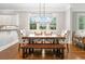 Bright dining area featuring a wooden table with upholstered chairs and a bench, complemented by hardwood floors and natural light at 3642 River Club Dr, Cumming, GA 30041