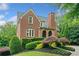 Well-maintained brick house showcasing manicured landscaping, mature trees and manicured lawn at 3642 River Club Dr, Cumming, GA 30041