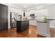 Modern kitchen with stainless steel appliances, white cabinetry, black countertops, and a dark-wood island on hardwood floors at 3642 River Club Dr, Cumming, GA 30041