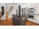 Open kitchen featuring stainless steel appliances, a dark-wood island, and white cabinets, connected to a staircase at 3642 River Club Dr, Cumming, GA 30041