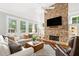 Bright living room with a stone fireplace, large windows, and comfortable seating arrangement at 3642 River Club Dr, Cumming, GA 30041
