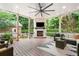 Covered patio with a stone fireplace and tv, offers relaxing seating and string lights for ambiance at 3642 River Club Dr, Cumming, GA 30041