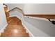 Stairway with hardwood steps and a wooden handrail on a white wall with molding at 3642 River Club Dr, Cumming, GA 30041