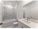 Bright bathroom featuring a bathtub with marble tile surround and a vanity with a large mirror at 207 Hickory Bluffs Pkwy, Canton, GA 30114