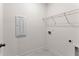 A well-lit laundry room with tile floors and a wire shelf above the washer/dryer hookups at 207 Hickory Bluffs Pkwy, Canton, GA 30114
