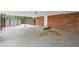 View of the carport with a brick facade, concrete flooring, and access to a shed at 9 Latimer Rd, Cartersville, GA 30121