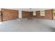 View of the carport with brick wall, white door, and concrete flooring at 9 Latimer Rd, Cartersville, GA 30121