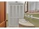 A compact half bath featuring a pedestal sink, a large mirror, and neutral finishes, ideal for guests and everyday convenience at 1125 Lanier Sw Dr, Marietta, GA 30060