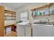 A well-lit laundry room equipped with modern washer and dryer units, complemented by ample shelving for organized storage at 1125 Lanier Sw Dr, Marietta, GA 30060