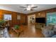 Large living room with wood paneled walls, ceiling fan, and access to other rooms at 1125 Lanier Sw Dr, Marietta, GA 30060